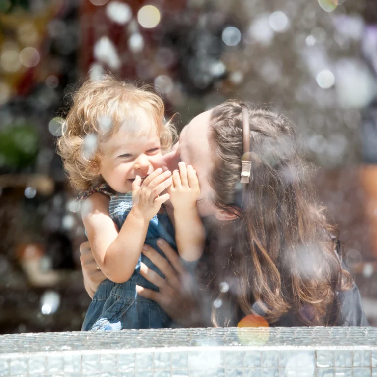 mum and daughter age 2 hugging each other in the park. - therachange.co.uk